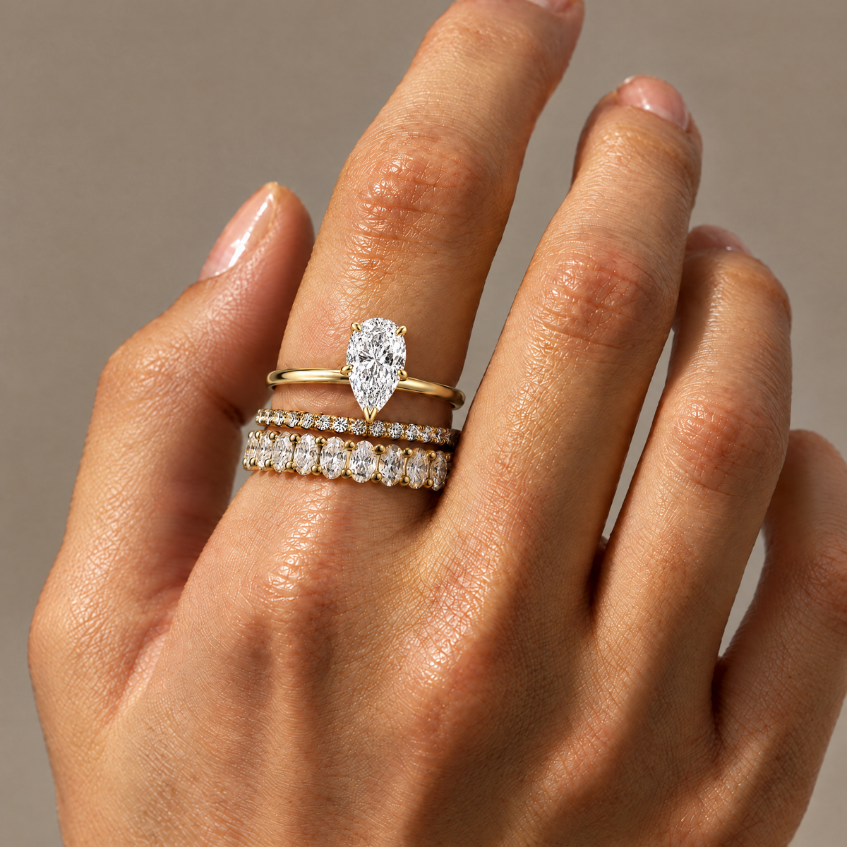 Pear Solitaire Ring stacked with two stone-set bands