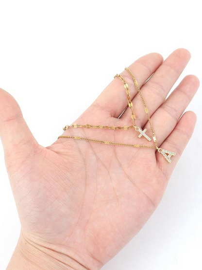 Set di 2 collane con ciondolo a croce e iniziali