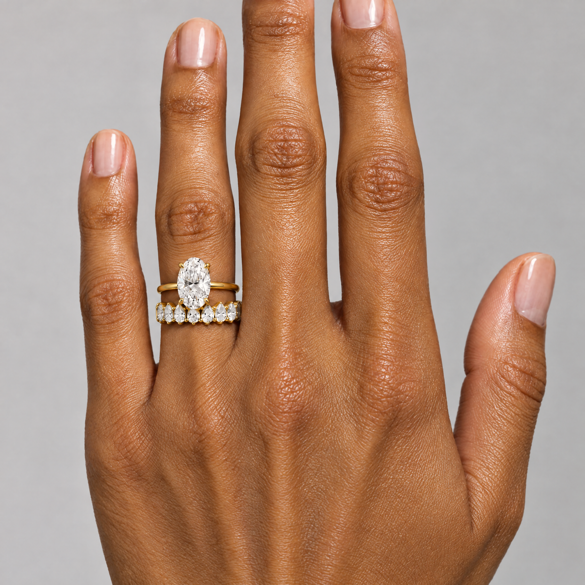 Pear Eternity Band Ring lying on travertine