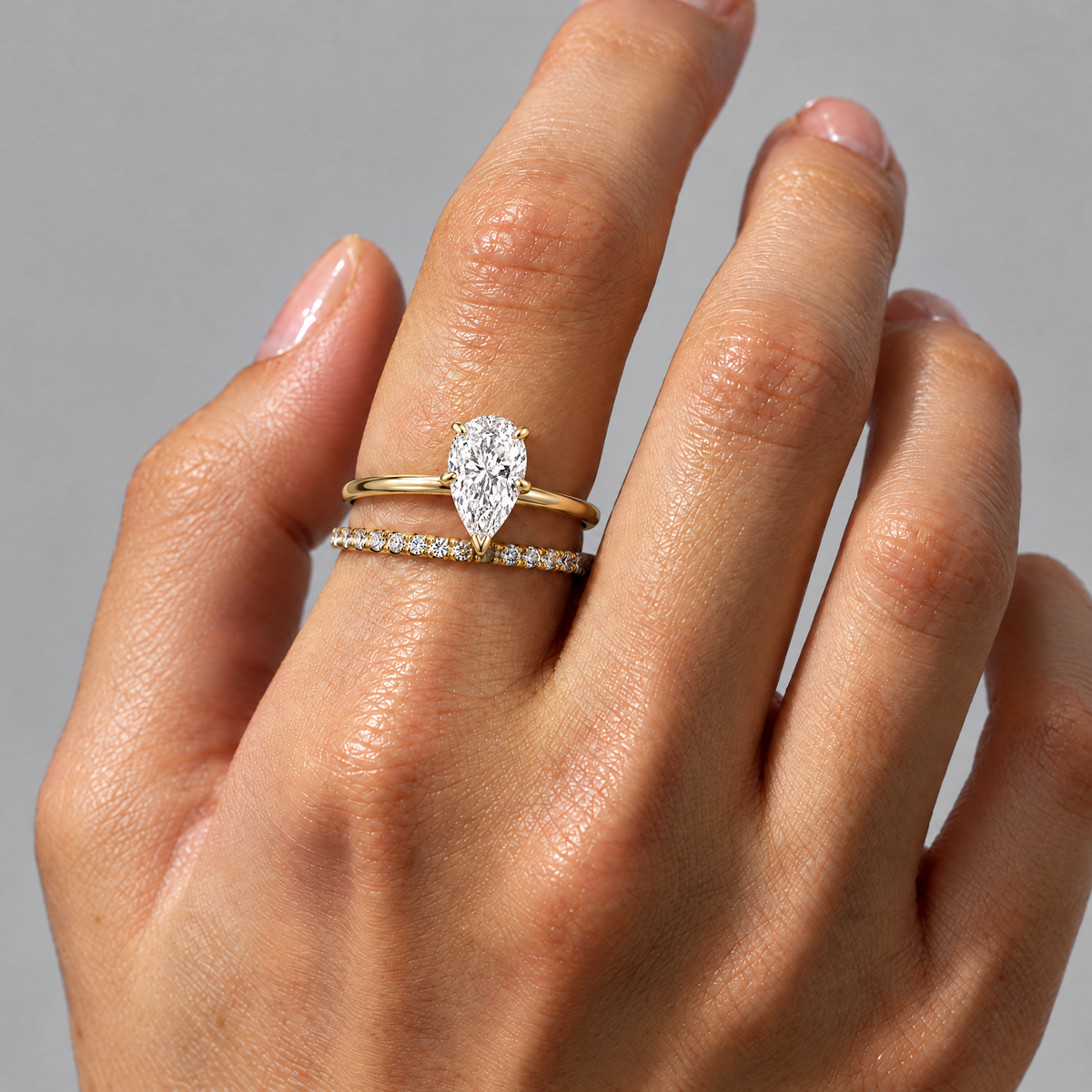 Pear Solitaire Ring stacked with a thin stone-set band