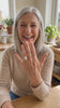 Woman happily showing the Grand Oval Solitaire Ring