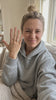 Woman showing the Round Solitaire Ring at home